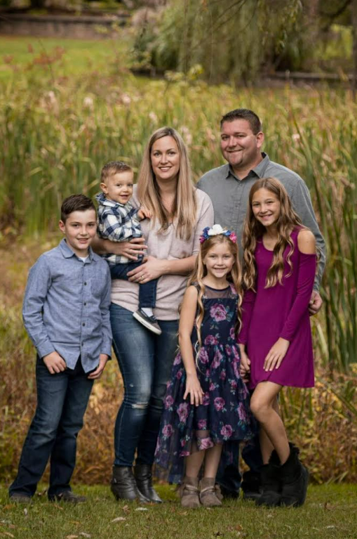 A family posing for a pictureDescription automatically generated with medium confidence